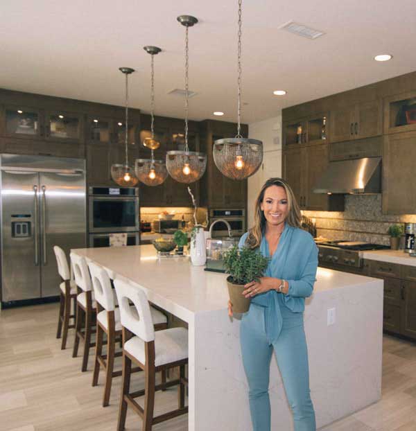 Woman holding a plant while standing in a kitchen