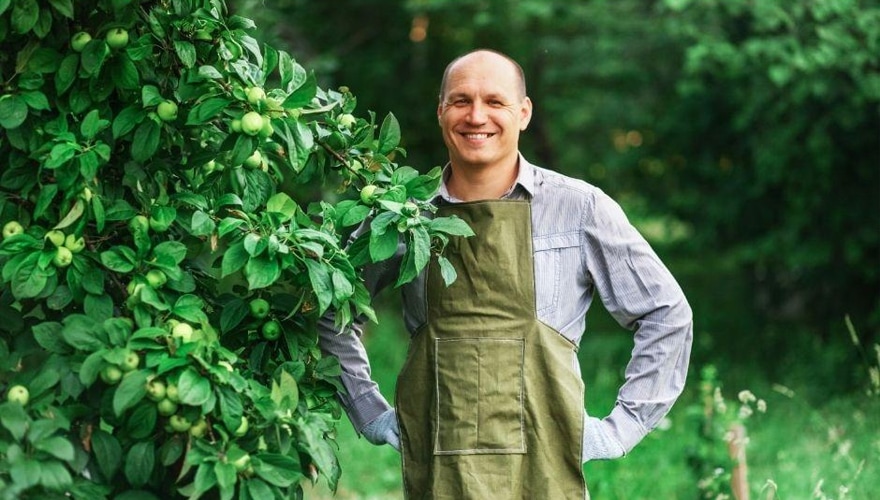 Garnener standing next to a fruit tree