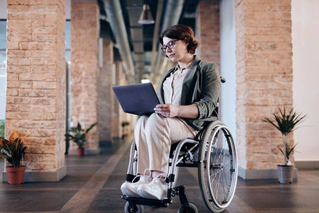 Woman in a Wheelchair Holding a Laptop