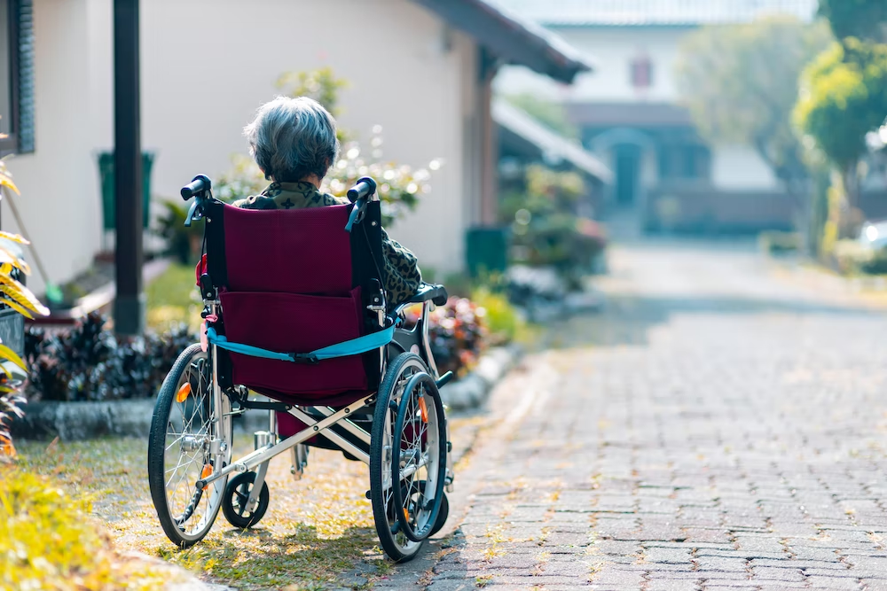 woman sitting on wheelchair on the sidewalk